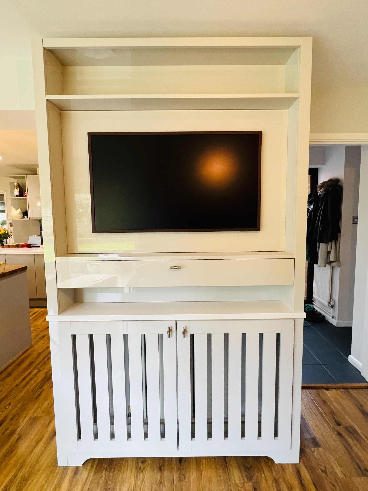 Finished bespoke TV unit with integrated radiator cover in a kitchen snug