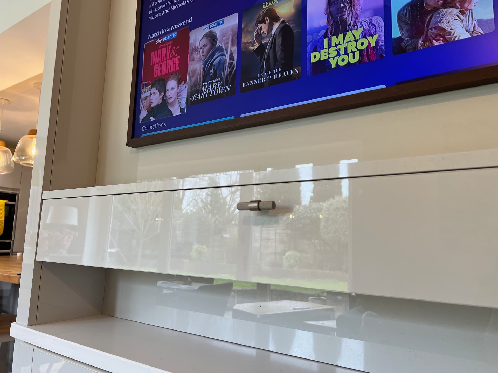 Close-up of the smooth drawer front and handle below the TV