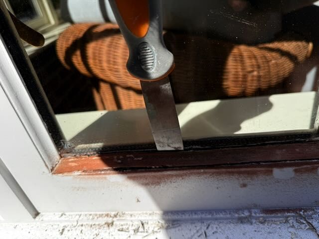Scraping failed material from a glazing bead by hand